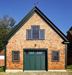 a brown brick house with green doors and windows