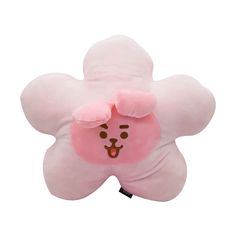 a pink flower shaped pillow with a smiley face on it's back and eyes closed