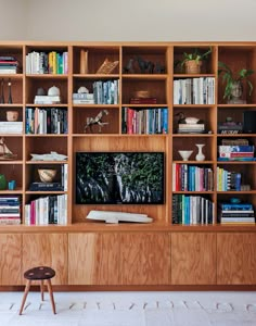 a woman standing on a ladder in front of a bookshelf