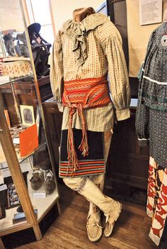 two mannequins dressed in native clothing standing next to each other on display