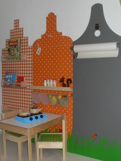 a child's playroom with an orange and white checkered wall behind the table