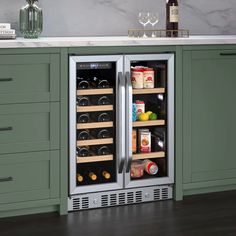 a wine cooler in the middle of a kitchen with green cabinets and white counter tops