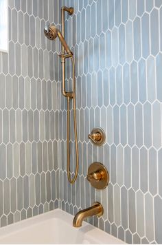 a bathtub with gold faucet and shower head