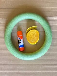 an object made out of felt and glue sitting on top of a wooden table next to a tube of toothpaste