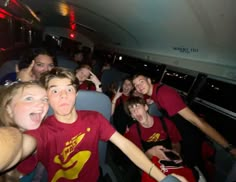 a group of young people riding on top of a bus