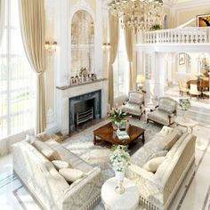 an elegant living room with chandelier, couches and fireplace in the center