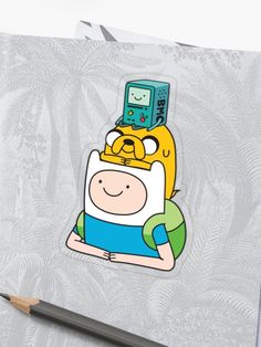 the adventure time finn sticker is sitting on top of a piece of paper next to a pencil