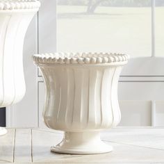 two white vases sitting next to each other on a table