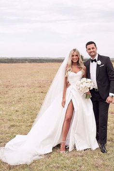 a bride and groom posing for a photo in the middle of an open field with tall grass