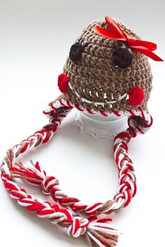 a crocheted hat with red and white braids