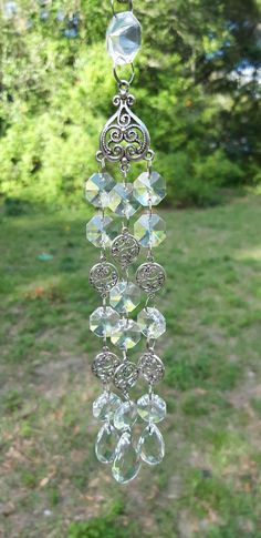 a glass wind chime hanging in the grass