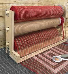 a pair of scissors are sitting next to some red and beige fabric on a table