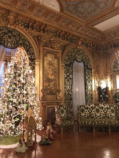 a christmas tree is in the middle of a room with ornate walls and gold trimmings