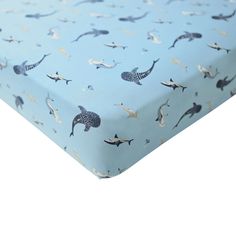 a baby blue sheet with an image of dolphins on it and gold foiled dots