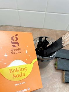 a wooden spoon with baking soda on it next to a box of good and gather