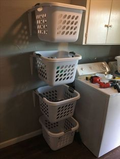 three laundry baskets stacked on top of each other next to a washer and dryer