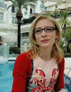 a woman sitting next to a swimming pool