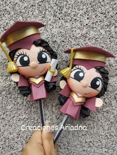 two small figurines that look like they are wearing graduation caps and gowns