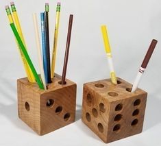 two wooden blocks with pencils and pens in them