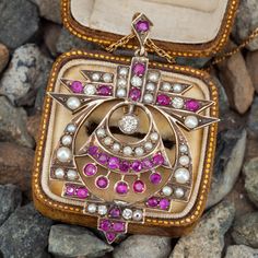 This beautiful pendant is accented with one (1), bezel set, round brilliant cut diamond, five (5), bead set, round brilliant cut diamonds, twenty-seven (27), bead set, oval/round mixed cut natural rubies and twenty-four (24), bead set, seed pearls. The pendant measures 52.1mm X 38.4mm. The pendant is suspended from a 14K yellow gold 18 inch long neck chain finished with a gold-filled spring ring clasp. Exquisite Diamond White Multi-stone Jewelry, Fine Jeweled Round Jewelry, Fine Jewelry With Oval Jeweled Details, Fine Jewelry With Jeweled Oval Details, Oval Jeweled Fine Jewelry, Jeweled Pendant Jewelry For Anniversary, Oval Pendant Jewelry With Rose Cut Diamonds, Rose Cut Diamond Jewelry With Oval Pendant, Oval Diamond Pendant With Rose Cut