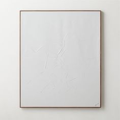 an abstract white painting with brown frame on the wall