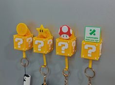 four key chains hanging on the wall with mario and luigi's question signs attached to them