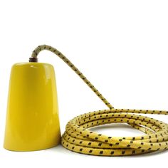 a yellow lamp with black dots on it next to a yellow hose that is connected to the light