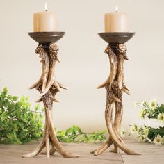 two candle holders made out of antlers on a table