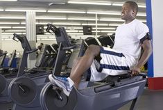 a man sitting on top of a machine in a gym