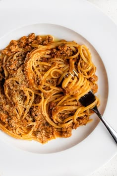 a white plate topped with spaghetti and meat