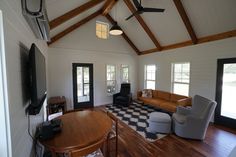 a living room filled with furniture and a flat screen tv on top of a wooden table