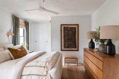 a bedroom with white walls and wood floors