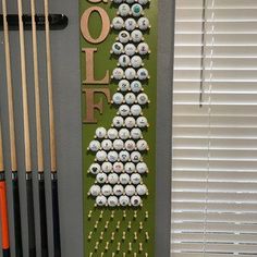 a rack with golf balls on it in front of a window next to cues and cues