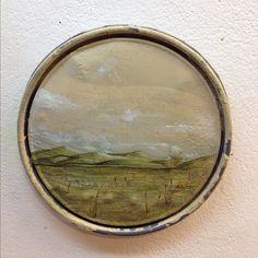 a painting on a white wall with a round frame