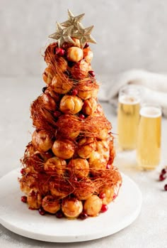 a small christmas tree made out of pretzels on a plate next to a glass of beer