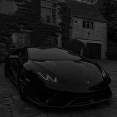 a black sports car parked in front of a house