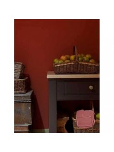 two wicker baskets on top of a table next to an old chest with drawers