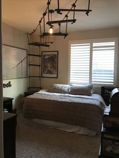 a bedroom with a bed, dresser and window