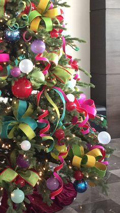 a brightly colored christmas tree decorated with bows