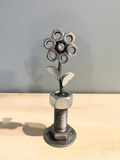 a metal flower sculpture sitting on top of a wooden table