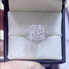 a cushion cut diamond ring in a box