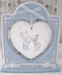 a blue and white heart shaped ornament with two children