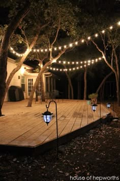 an outdoor deck lit up with string lights