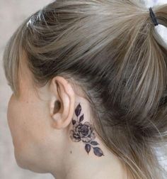 a woman with a flower tattoo on her left side behind her ear and behind her ear is a black rose