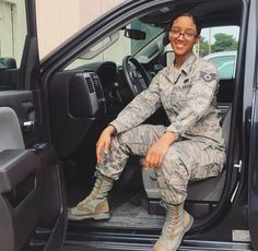 a woman in uniform sitting on the door of a truck