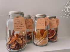 three glass jars filled with different types of dried fruits and nuts, labeled with tags