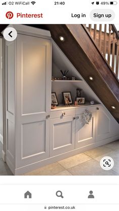 an under the stairs storage area with built in bookshelves and cabinets underneath it