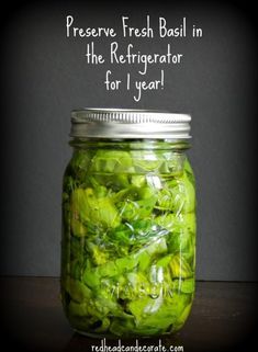 a jar filled with green vegetables sitting on top of a table