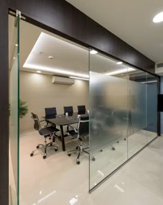 an empty conference room with glass walls and chairs