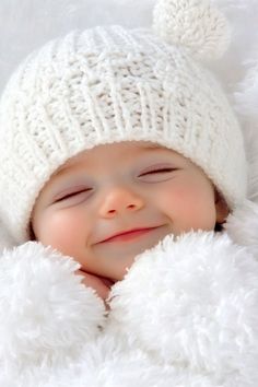 a smiling baby wearing a white knitted hat